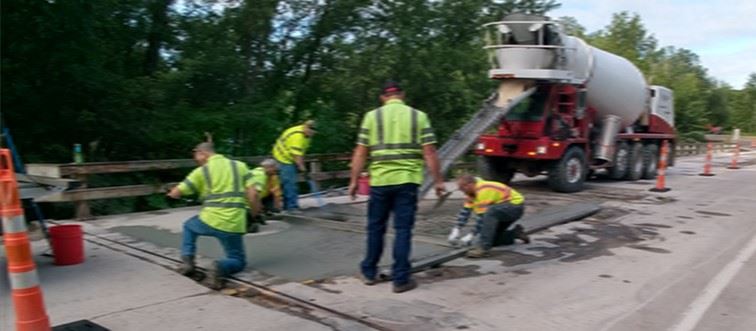 Highway workers pouring concrete